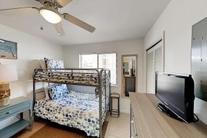 - une chambre avec des lits superposés et une télévision à écran plat dans l'établissement Wolf Bay Villas, à Orange Beach
