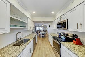 cocina con armarios blancos y comedor en Bay View Villas #118 en Clearwater Beach