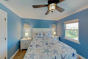 1 dormitorio azul con 1 cama y ventilador de techo en Bay View Villas #118 en Clearwater Beach