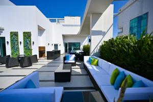 an outdoor patio with blue and white furniture and plants at Springfield Suites in Seef