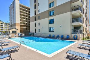 a swimming pool with chairs and a building at Sandpiper Dunes II in Ocean City