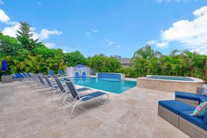a group of chairs and a swimming pool at Seas the Day in West Palm Beach