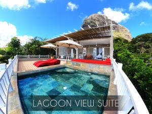 a villa with a swimming pool in front of a house at Kozy Le Morne in Le Morne