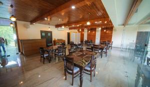 a dining room with wooden tables and chairs at Hotel Social Palace, Uttarkashi in Uttarkāshi
