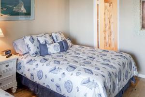 Schlafzimmer mit einem Bett mit blauer und weißer Bettwäsche in der Unterkunft Siesta Villa in Ocean City