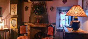 una sala de estar con chimenea y una lámpara en una mesa. en Room in Guest room - Romantic Christmas at La Quinta de Malu, en Valera de Arriba