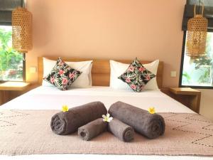 a bedroom with a bed with two rolled towels on it at Le Chien Rouge in Lovina +40 photos