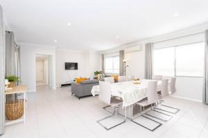 un soggiorno bianco con tavolo e divano di The Kingsley’s Place - EXECUTIVE ESCAPES a Perth