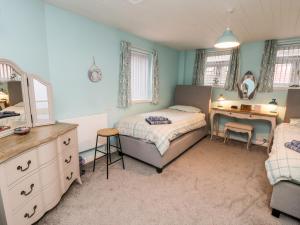 a bedroom with a bed and a desk with a mirror at Bramla in Staithes
