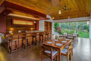 a dining room with wooden tables and chairs at StayVista at Tall Silver with Infinity Pool & Breakast in Madikeri
