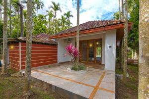 a small house with a patio in front of it at StayVista at Tall Silver with Infinity Pool & Breakast in Madikeri
