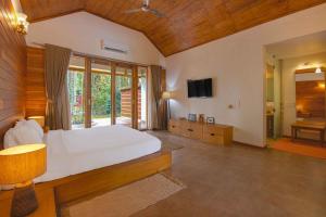 a large bedroom with a bed and a television at StayVista at Tall Silver with Infinity Pool & Breakast in Madikeri