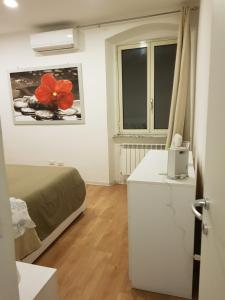 a bedroom with a bed and a desk with a phone at Fontana Grande Apartment in Viterbo