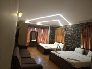 een hotelkamer met 2 bedden en een bank bij Western Valley Home stay in Kodaikānāl