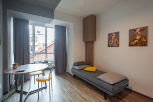 a living room with a bed and a table at Like Home on IN in Ivano-Frankivsʼk