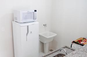 uma casa de banho com um micro-ondas em cima de um WC em Apartamento aconchegante em Petrópolis