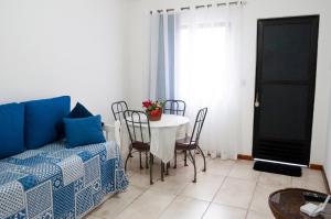 ein Wohnzimmer mit einem Tisch, Stühlen und einem Sofa in der Unterkunft Apartamento aconchegante in Petrópolis