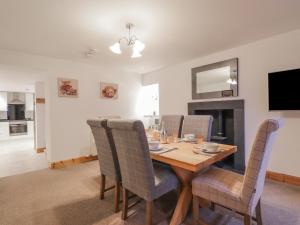 comedor con mesa de madera y sillas en Nanville en Beauly