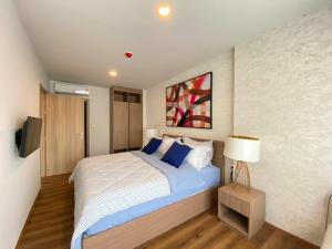 une chambre avec un grand lit avec des oreillers bleus dans l'établissement LA HABANA501, à Hua Hin