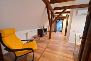een gele stoel in een woonkamer met houten vloeren bij FLH - Limette Home in Sibiu