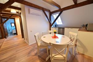 een keuken en eetkamer met een witte tafel en stoelen bij FLH - Limette Home in Sibiu