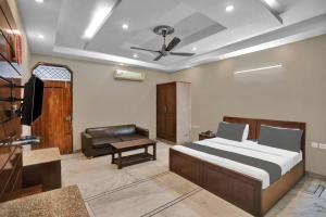 a bedroom with a bed and a living room with a couch at HOTEL OM PLAZA in New Delhi