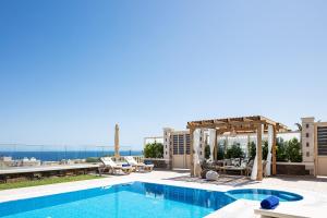 a pool on the roof of a building with a view at Agapi Villas I & II, fairytale seaside retreats, By ThinkVilla in Panormos Rethymno