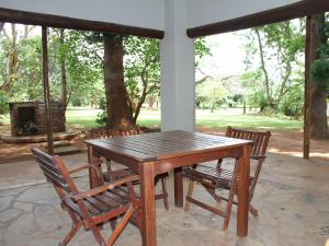 a wooden table and chairs on a patio at Sandforest Cottages in Hluhluwe