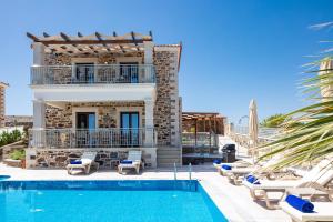 a villa with a swimming pool and a house at Agapi Villas I & II, fairytale seaside retreats, By ThinkVilla in Panormos Rethymno