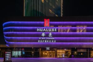 ein Gebäude, das nachts in lila leuchtet in der Unterkunft HUALUXE Xi'an Chanba, an IHG Hotel in Xi'an