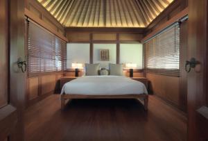 a bedroom with a bed in a room with windows at The Legian Seminyak, Bali in Seminyak