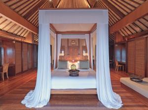 a bed with a canopy in a room at The Legian Seminyak, Bali in Seminyak