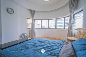 a bedroom with a blue bed with a large window at Doorstep - Sunway Putra Mall - Close to PWTC for 4 in Kuala Lumpur