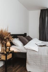 1 dormitorio con 1 cama y 1 mesa con lámpara en Sniegi Apartments with sauna, en Madona