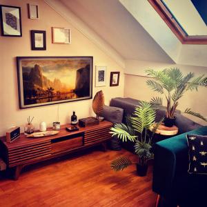 a living room with a couch and a painting on the wall at Birdland Apartman in Bük