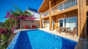 a villa with a swimming pool in front of a house at Eco villa Karanfil in Kalkan