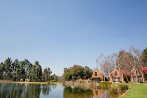 - une vue sur un lac avec des maisons en arrière-plan dans l'établissement Critchley Hackle, à Dullstroom