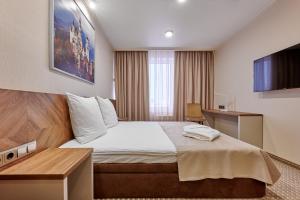 ein Hotelzimmer mit einem Bett und einem Schreibtisch in der Unterkunft Tourist Hotel in Omsk