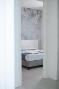 a bedroom with a bed and a wall with flowers at MAR60 Apartments in Caorle