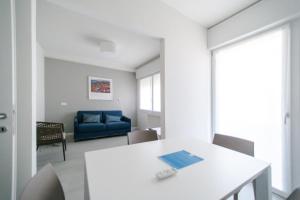 a living room with a white table and a blue couch at MAR60 Apartments in Caorle