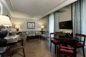 
a living room filled with furniture and a tv at Rocco Forte Hotel De La Ville in Rome
