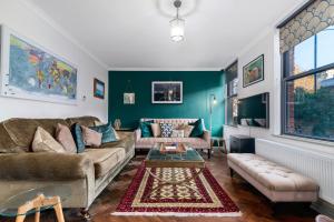 ein Wohnzimmer mit einem Sofa und einem Tisch in der Unterkunft GuestReady - Beautiful 2BR Townhouse w Garden in London