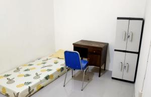 Schlafzimmer mit einem Bett, einem Schreibtisch und einem blauen Stuhl in der Unterkunft Kabin Kapsule UI Depok - Male Only in Jakarta