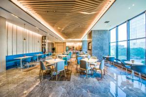 a restaurant with tables and chairs and windows at Holiday Inn Express Foshan Beijiao by IHG in Shunde