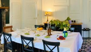 a table with a white table cloth and a vase of flowers at Domaine La Reveille in Dore-lʼÉglise