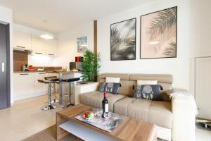 een woonkamer met een bank en een tafel bij Le Charme YourHostHelper in Cannes