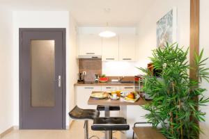 een keuken met witte kasten en een tafel en stoelen bij Le Charme YourHostHelper in Cannes +13 foto's