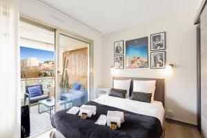 een slaapkamer met een groot bed en een balkon bij Le Charme YourHostHelper in Cannes