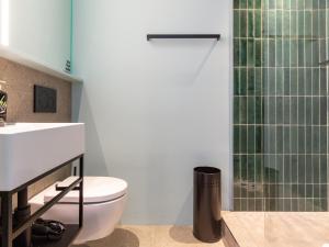 a bathroom with a toilet and a glass shower at Limehome Rottenburg am Neckar Poststraße in Rottenburg +11 photos