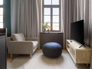 a living room with a chair and a tv at limehome Rottenburg am Neckar Poststraße in Rottenburg